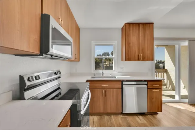 a kitchen with stainless steel appliances granite countertop a stove a sink and a microwave
