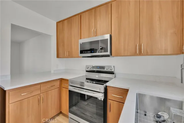 a kitchen with granite countertop white cabinets and black appliances