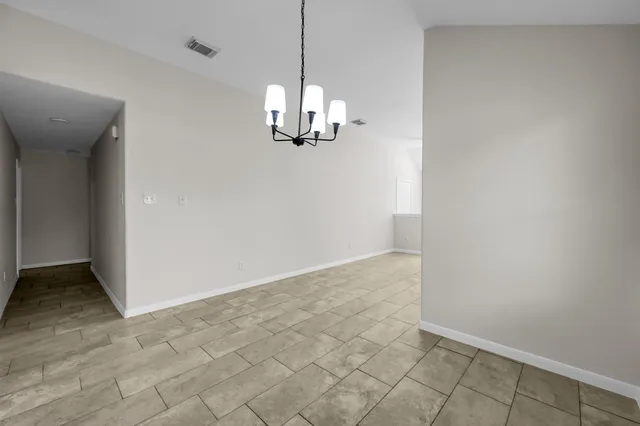 an empty room with kitchen view