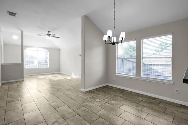 a view of a livingroom with a chandelier fan and windows