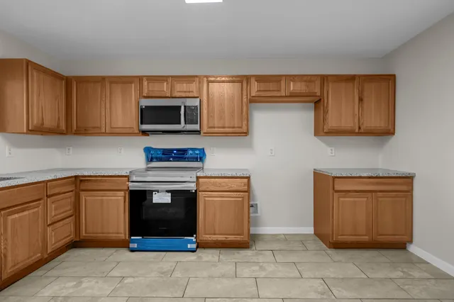 a kitchen with stainless steel appliances granite countertop a stove top oven and cabinets