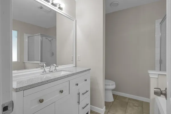 a bathroom with a granite countertop sink a toilet and a mirror