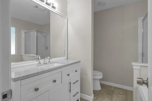 a bathroom with a granite countertop sink a toilet and a mirror