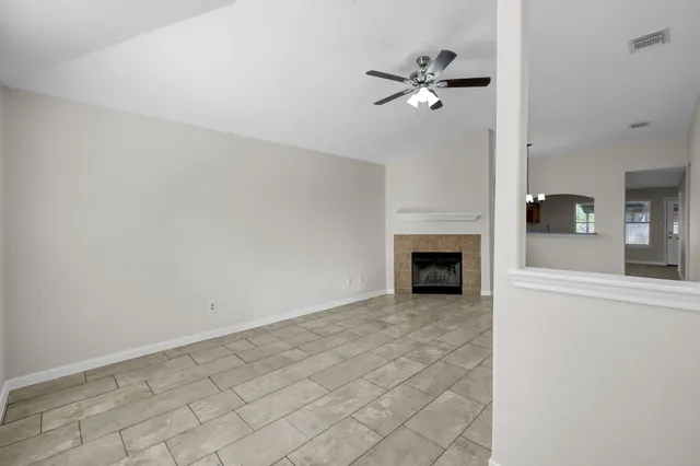 a view of a livingroom with a fireplace and a chandelier fan