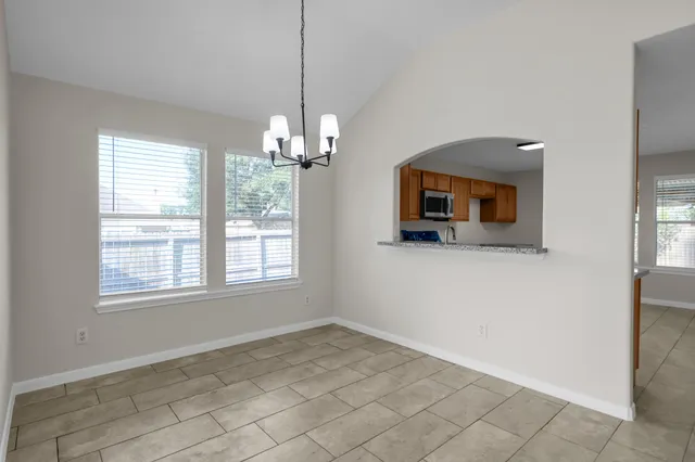 a view of a livingroom with a chandelier windows and fireplace
