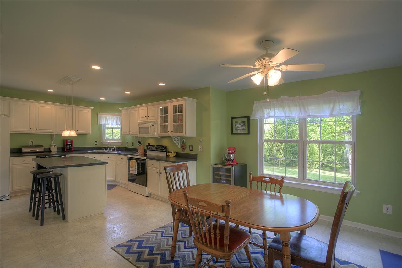 153 Deerview Road Keswick, VA 22947 - Photo 16 of 31 a kitchen with a dining table chairs and stove