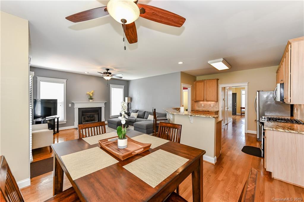 1036 Hunters Run Drive Tega Cay, SC 29708 - Photo 16 of 35 a living room with furniture a fireplace and kitchen view