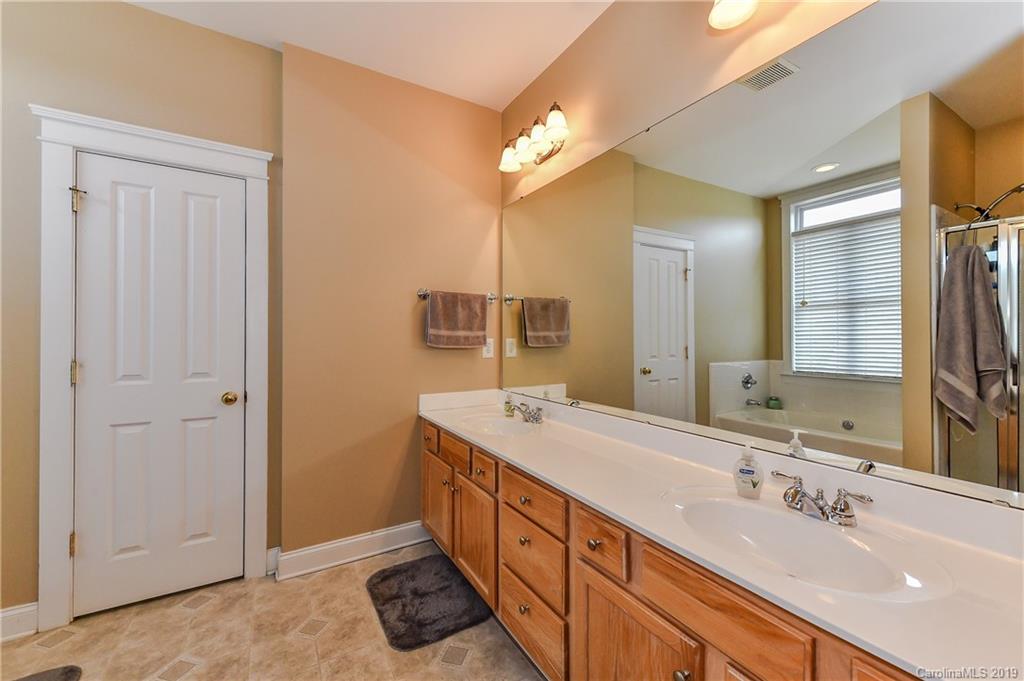 1036 Hunters Run Drive Tega Cay, SC 29708 - Photo 22 of 35 a spacious bathroom with a double vanity sink and a mirror
