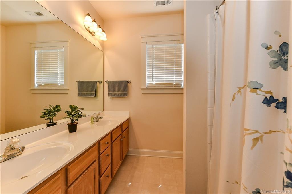 1036 Hunters Run Drive Tega Cay, SC 29708 - Photo 26 of 35 a bathroom with a double vanity sink a mirror and a shower