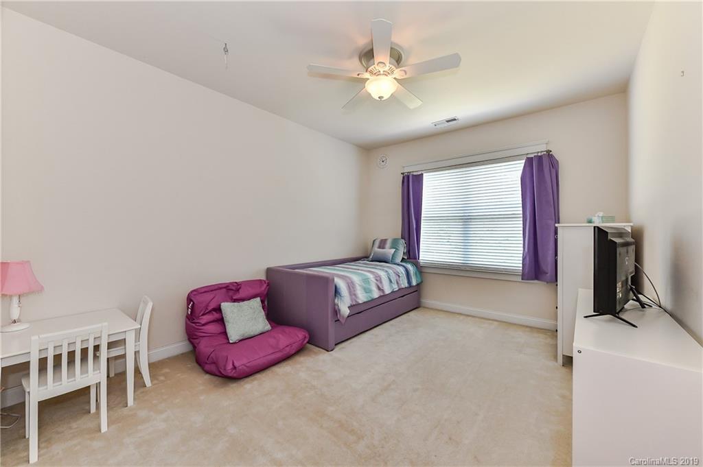 1036 Hunters Run Drive Tega Cay, SC 29708 - Photo 27 of 35 a spacious bedroom with a bed and a chandelier