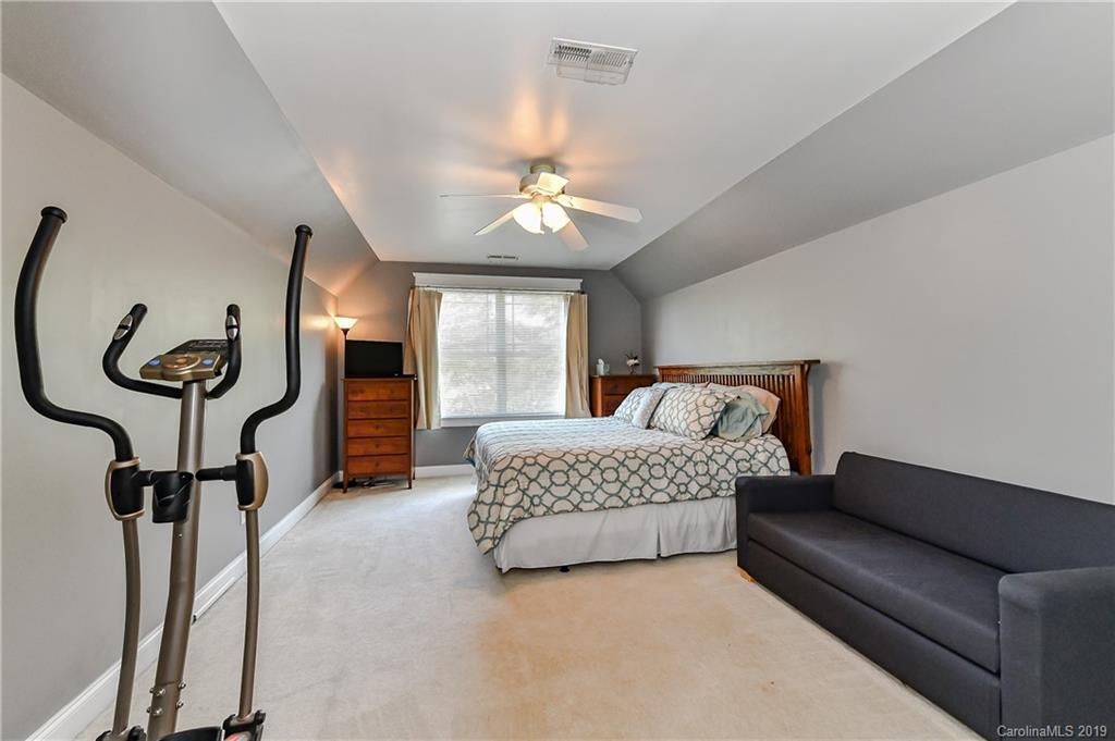 1036 Hunters Run Drive Tega Cay, SC 29708 - Photo 28 of 35 a spacious bedroom with a bed and a chandelier