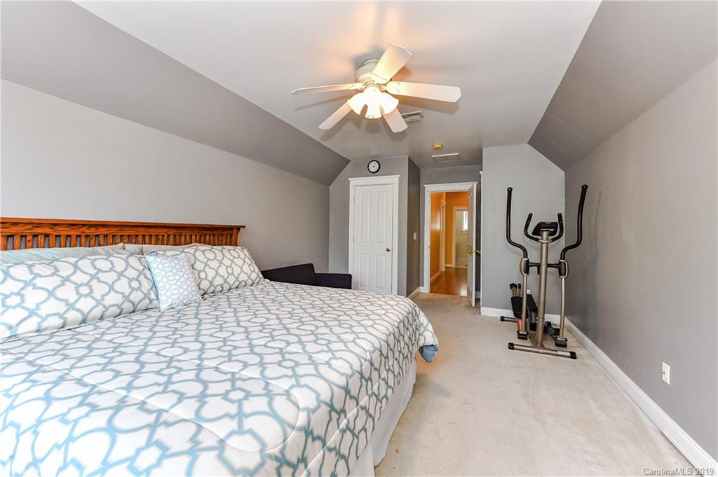 1036 Hunters Run Drive Tega Cay, SC 29708 - Photo 29 of 35 a bedroom with a bed and a chandelier