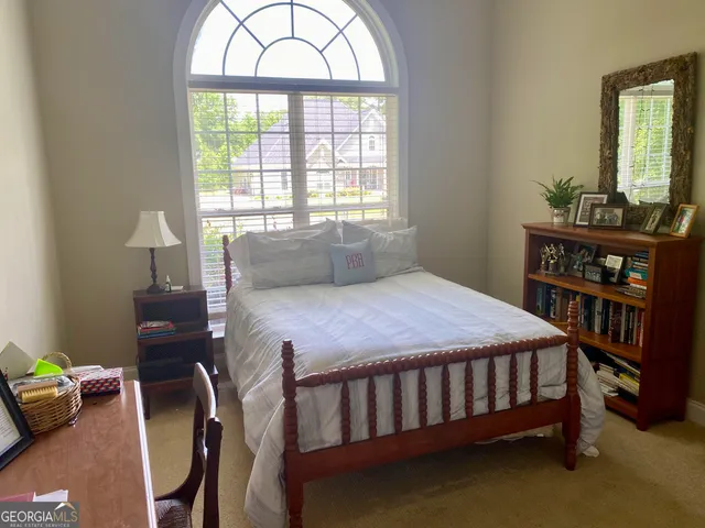 a bedroom with a bed a bookshelf and a window