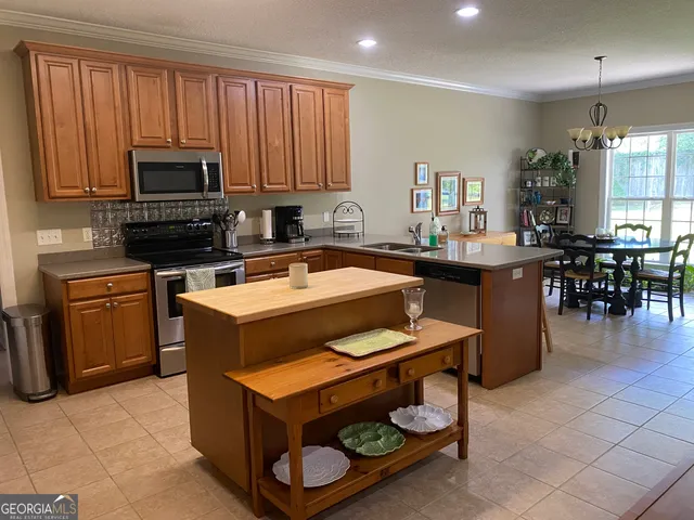 a kitchen with a sink a stove and chairs