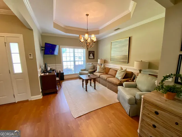 a living room with furniture and a chandelier