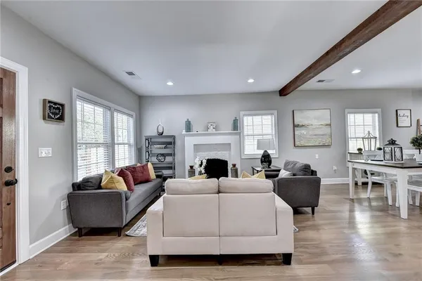 a living room with furniture a fireplace and a large window