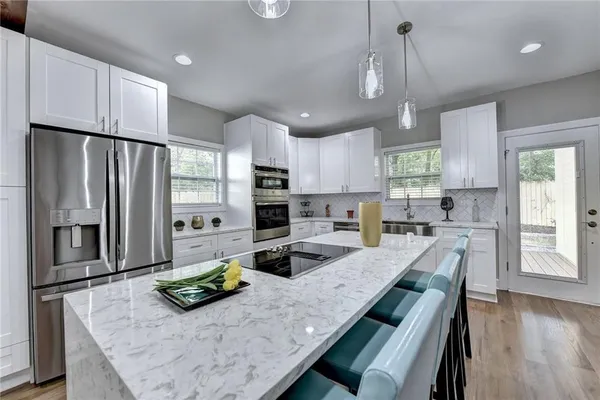 a kitchen with stainless steel appliances granite countertop a sink refrigerator and microwave