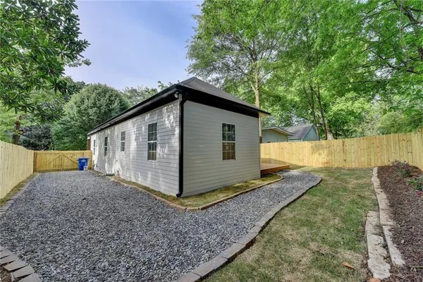 a view of backyard of house with wooden fence