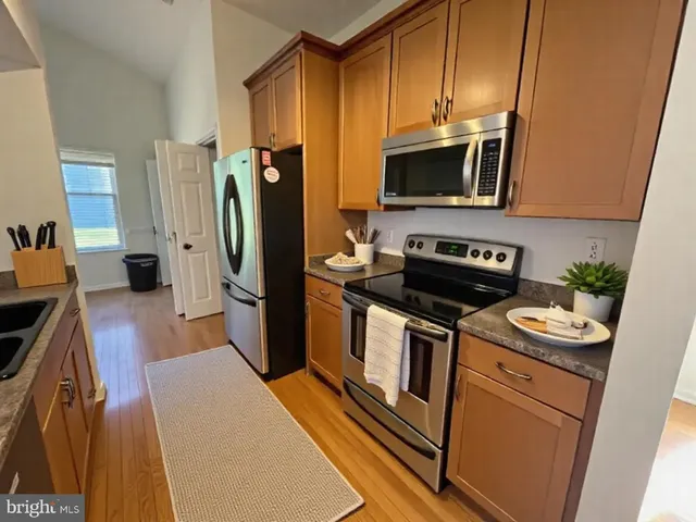 a kitchen with stainless steel appliances a stove microwave and refrigerator