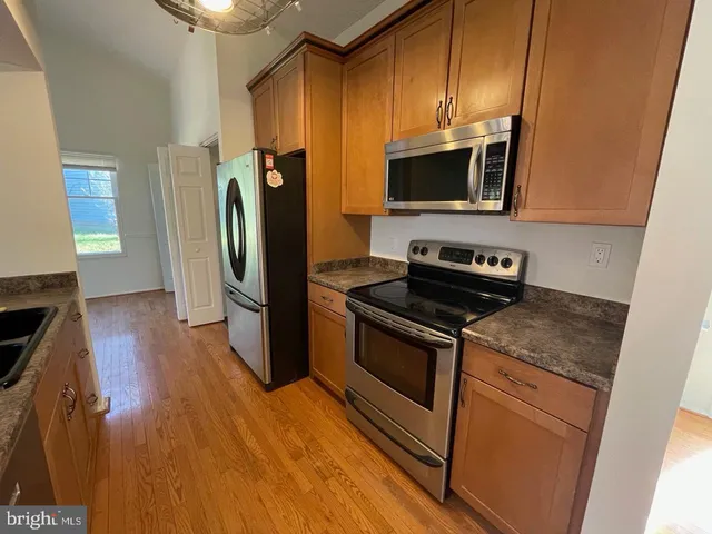 a kitchen with stainless steel appliances granite countertop a refrigerator microwave and stove