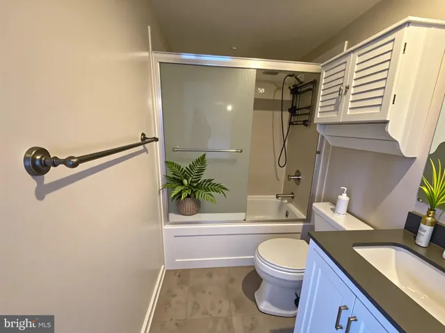 a bathroom with a granite countertop sink toilet a mirror and shower
