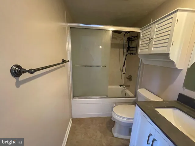 a bathroom with a granite countertop toilet sink and shower