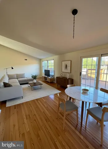 a living room with dining room and wooden floor
