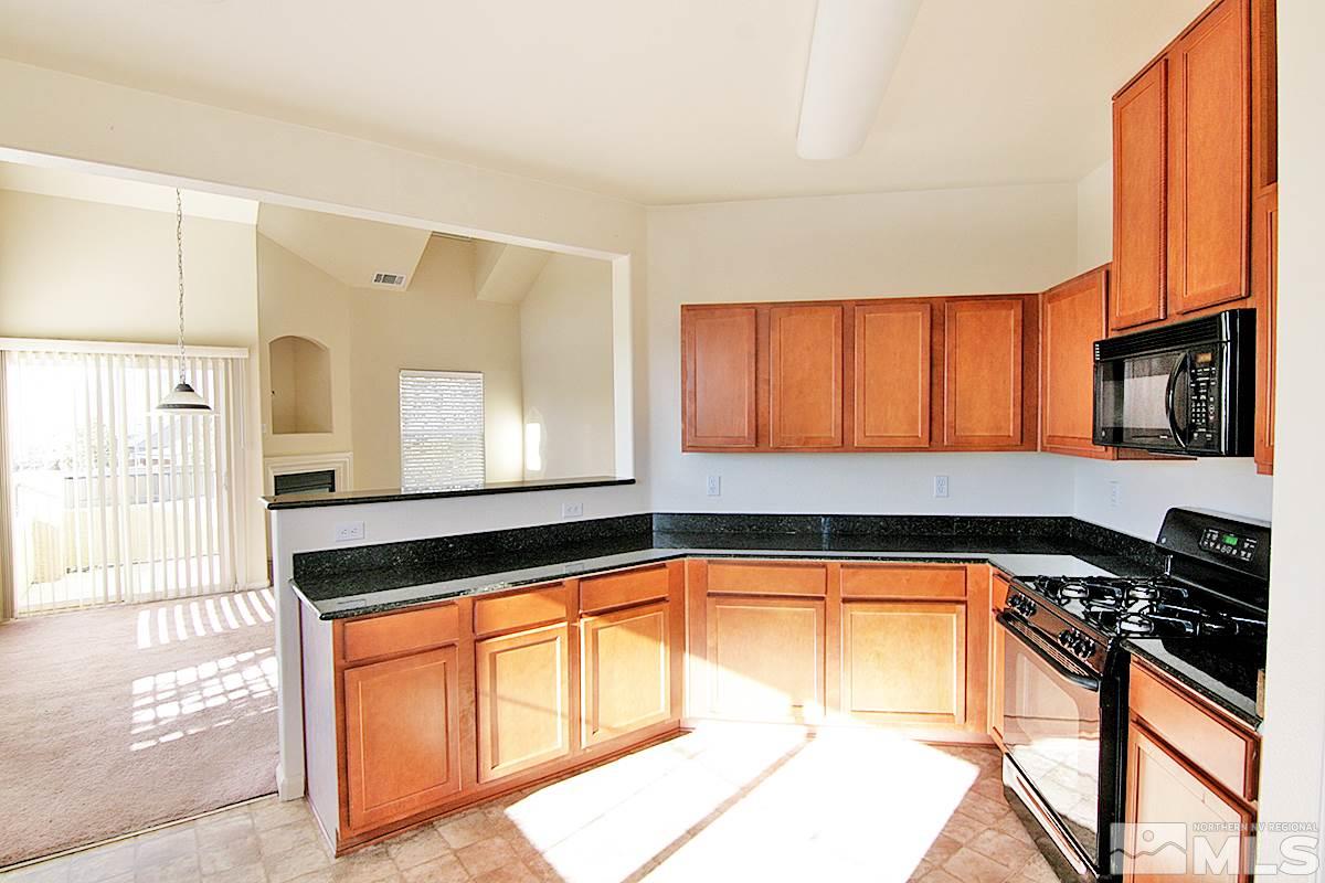 9050 Double R, Unit 225 Reno, NV 89521 - Photo 11 of 29 a kitchen with stainless steel appliances granite countertop a stove a sink and a microwave