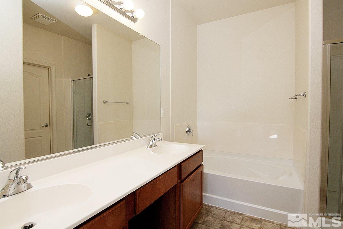 9050 Double R, Unit 225 Reno, NV 89521 - Photo 13 of 29 a bathroom with a tub sink and mirror
