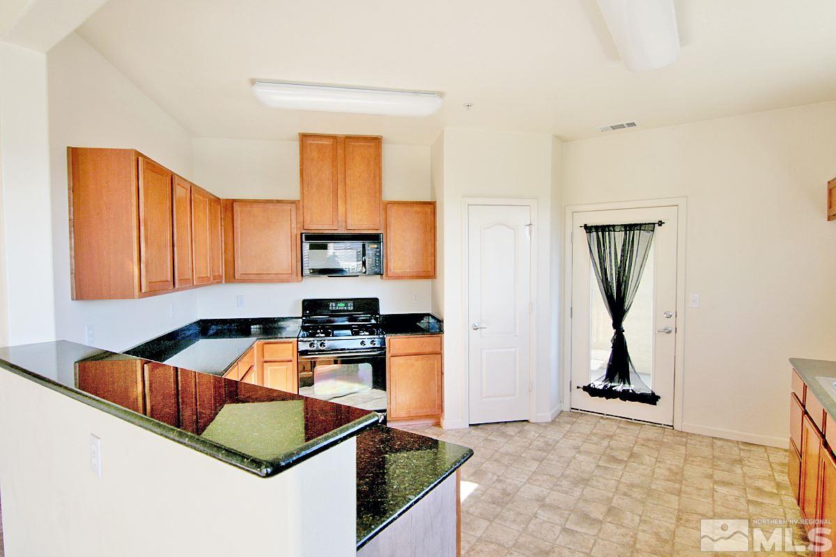 9050 Double R, Unit 225 Reno, NV 89521 - Photo 8 of 29 a kitchen with stainless steel appliances granite countertop a sink stove and refrigerator