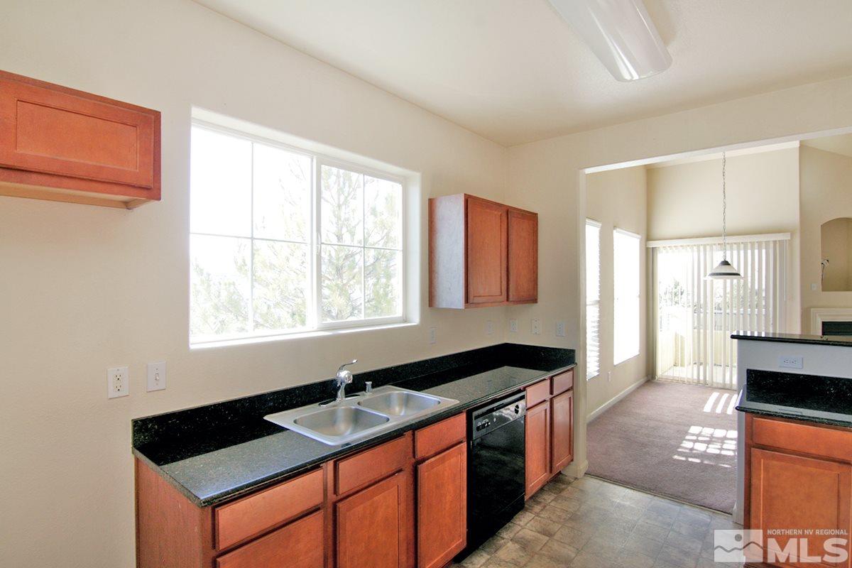 9050 Double R, Unit 225 Reno, NV 89521 - Photo 9 of 29 a kitchen with granite countertop a stove a sink and a refrigerator