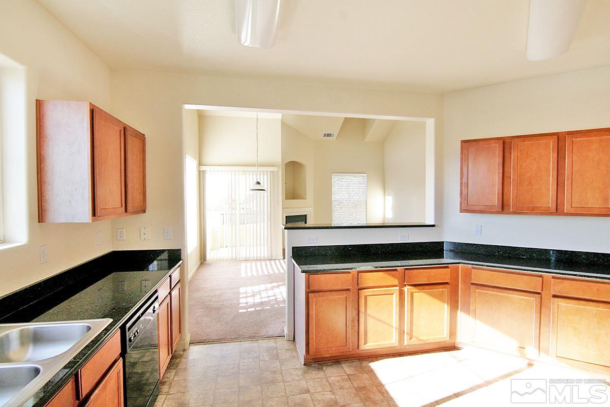 9050 Double R, Unit 225 Reno, NV 89521 - Photo 10 of 29 a kitchen with granite countertop a sink a stove and cabinets