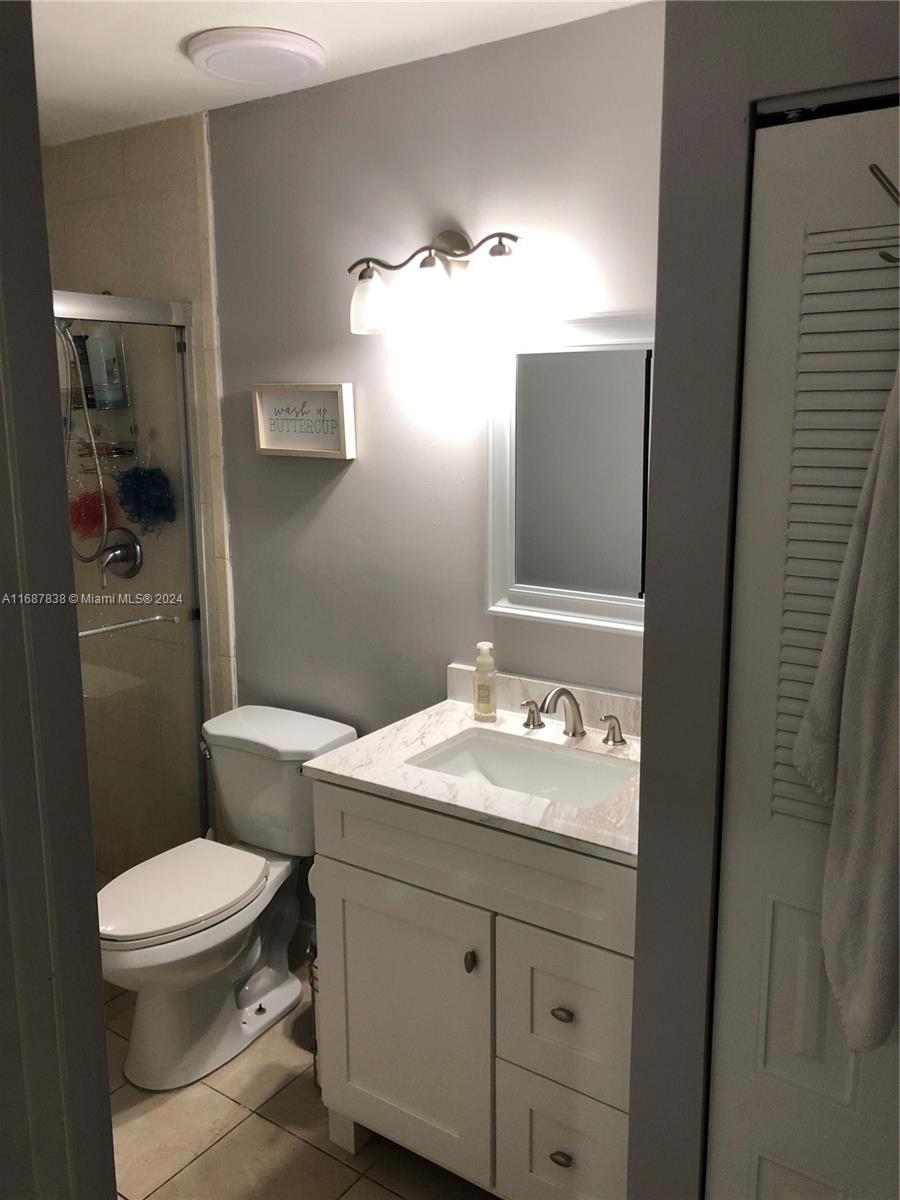 14010 Southwest 91st Terrace, Unit 14010 Miami, FL 33186 - Photo 5 of 6 a bathroom with a sink a toilet a mirror and vanity