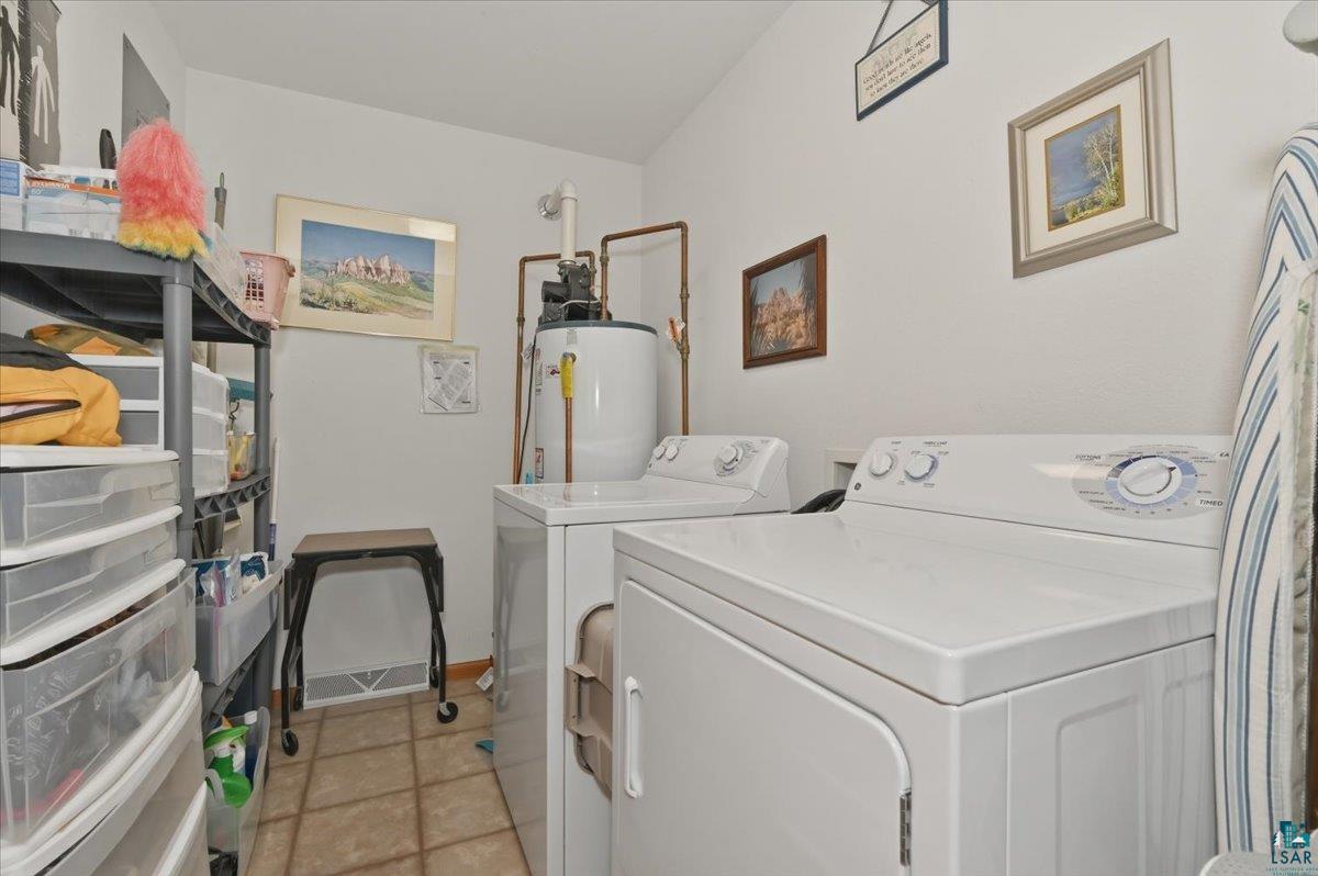 8162 South Dowling Road West Superior, WI 54880 - Photo 10 of 15 Dedicated laundry area featuring a white washing machine and dryer, tile flooring, and a water heater