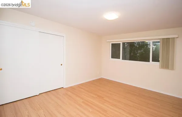 a view of a big room with wooden floor and windows