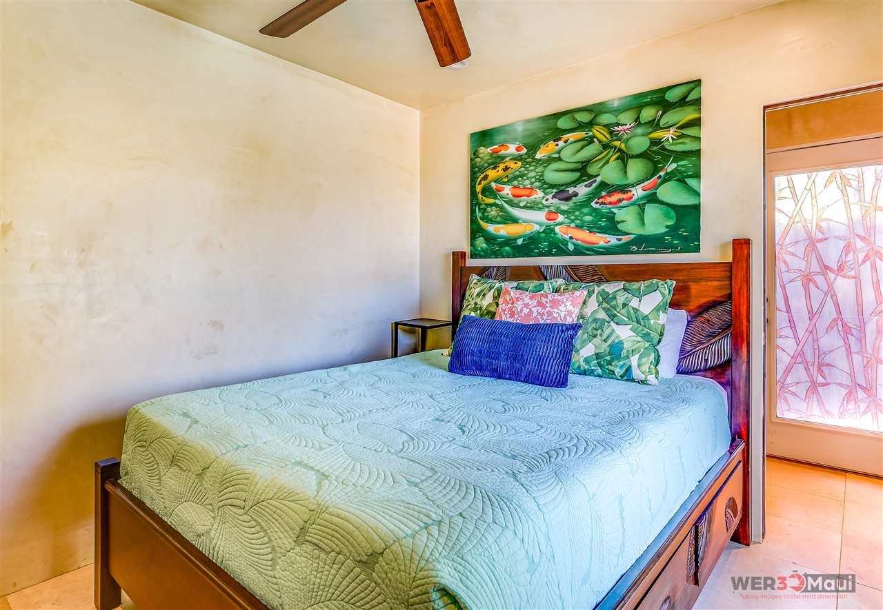 52 Lau Niu Way, Unit A Lahaina, HI 96761 - Photo 24 of 28 a bedroom with a bed and painting on the wall