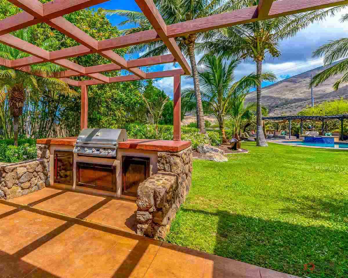 52 Lau Niu Way, Unit A Lahaina, HI 96761 - Photo 6 of 28 a view of a patio with table and chairs potted plants and palm trees