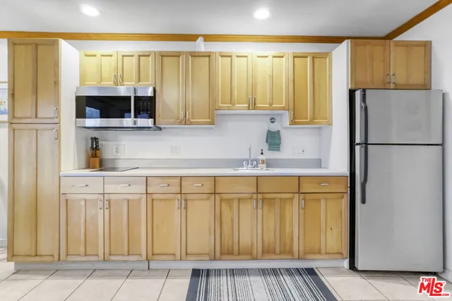 a kitchen with a refrigerator a sink and cabinets