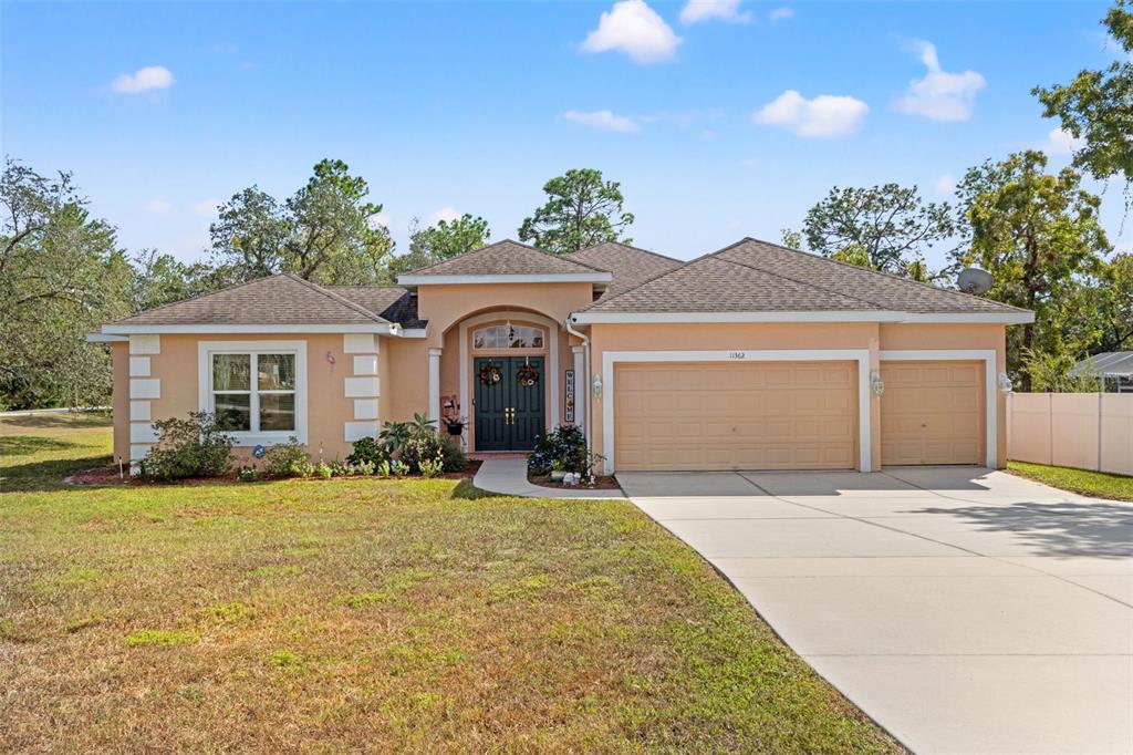 11362 Fool Duck Avenue Weeki Wachee, FL 34613 - Photo 1 of 1 a front view of a house with a yard and garage