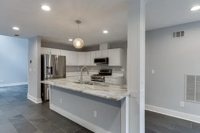 a kitchen with stainless steel appliances granite countertop a sink refrigerator and cabinets