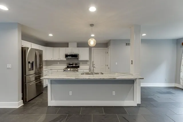 a kitchen with kitchen island a sink stainless steel appliances and cabinets