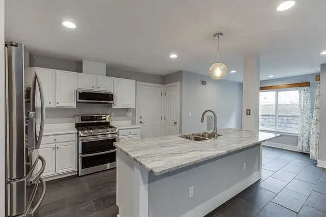 a kitchen with stainless steel appliances granite countertop a sink stove and refrigerator
