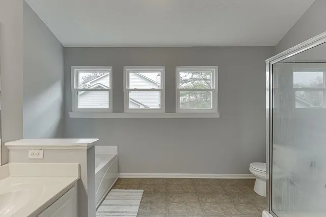 a bathroom with a tub a sink and mirror