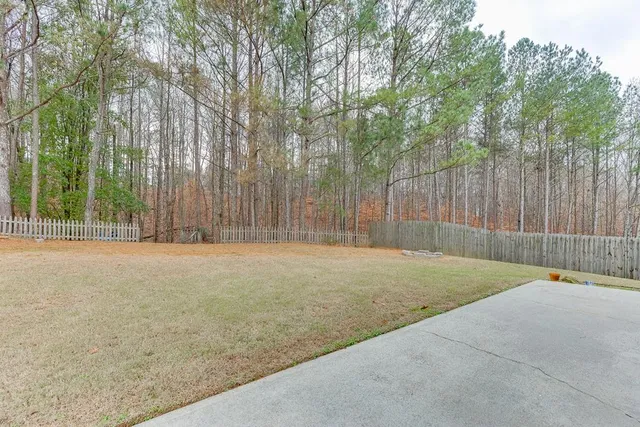 a view of a house with backyard and trees