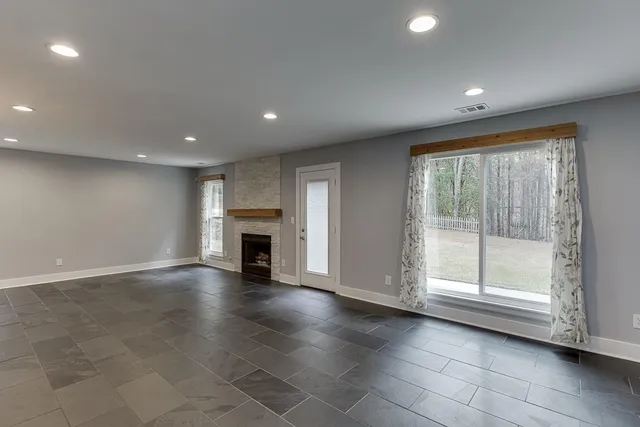 a view of empty room with wooden floor and fireplace