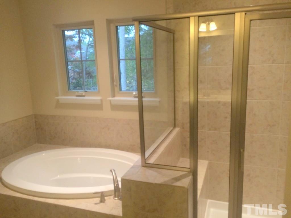 3916 Cary, NC 27519 - Photo 12 of 16 a bathroom with a bathtub and a shower