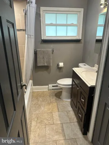 a bathroom with a granite countertop sink toilet and a mirror