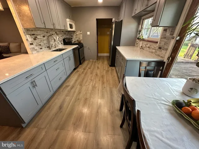 a kitchen with cabinets a sink dishwasher and a stove with wooden floor