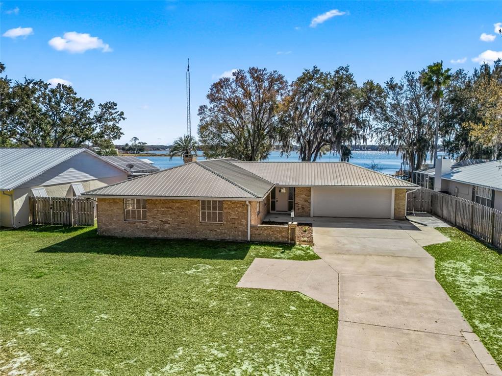 a view of a house with a yard and large trees