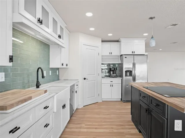 a large kitchen with kitchen island a large window a sink and living room view